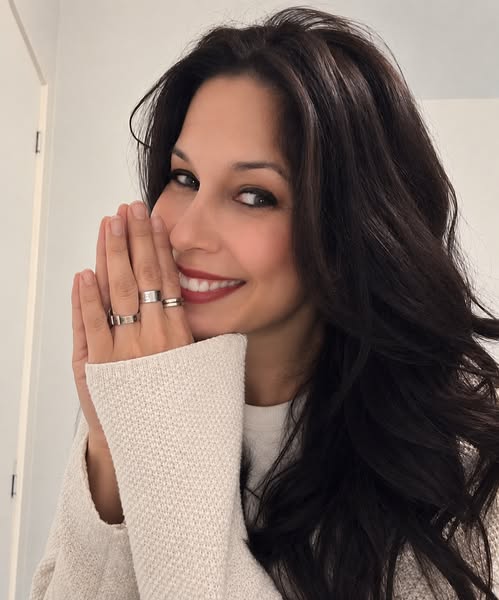 Gaby Ramírez smiles, in a light sweater, hands together near her face